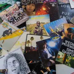 Bunte Schallplatten zeigen, welche Musikrichtungen es gibt: Rock von AC/DC, Pop von Genesis, Reggae von Bob Marley und mehr.