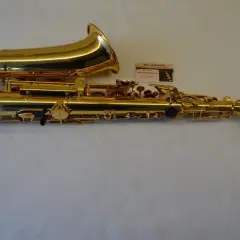 Glänzendes goldenes Saxophon mit einer kleinen Karte, die eine Saxophon-Beschriftung zeigt.