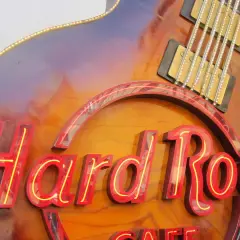 Hard Rock Cafe-Schild in Gitarrenform, das an die besten Songs der 70er erinnert.