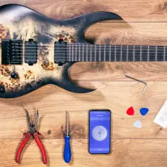 Gitarre mit Werkzeug und Handy-App zur Einstellung des Saitenabstands.