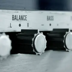 Nahaufnahme von Reglern eines Verstärkers: VOLUME, BALANCE, BASS. Ein Drehknopf für den gain regler ist gut sichtbar.