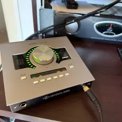 Universal Audio Apollo Twin X Audio-Interface auf einem Schreibtisch, bereit für Aufnahmen.