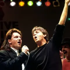 Bono und Paul McCartney singen bei Live Aid. Freddie Mercury jubelt im Hintergrund. Legendäre Live Aid Bands vereint.
