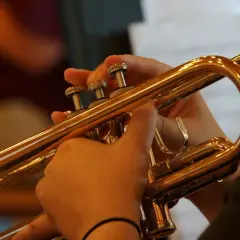 Hände spielen eine glänzende Trompete. Ob das **ist trompete lernen schwer**? Übung macht den Meister!