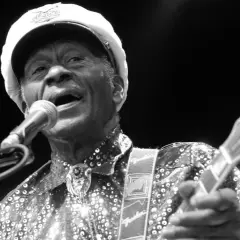 Chuck Berry, ein verstorbener Rockmusiker, singt ins Mikrofon und spielt Gitarre.