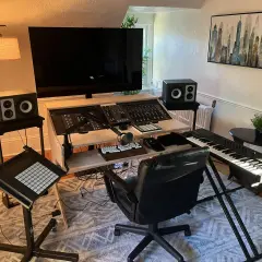 Ein Musikstudio mit einem großen Bildschirm, Mischpult, Tastatur und einem Plattenspieler für das perfekte **vinyl setup**.