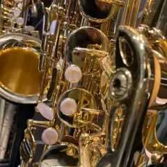 Glänzende, goldene Saxophone im Detail. Verschiedene saxophon arten sind zu sehen, mit ihren Klappen und dem Schallstück.