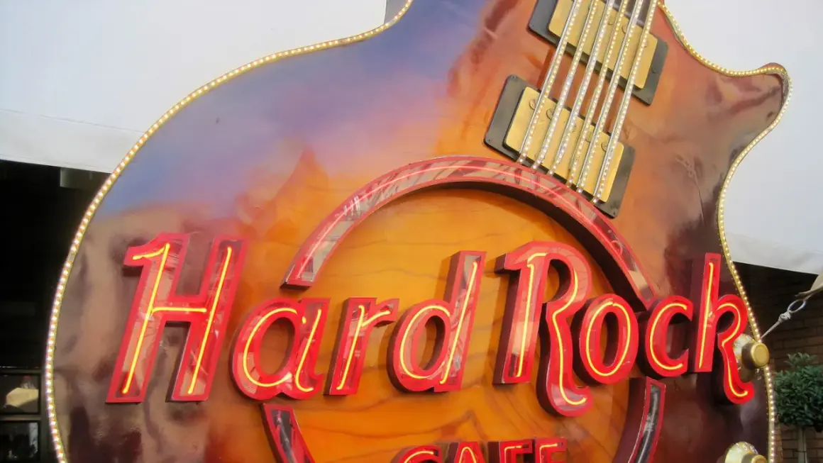 Hard Rock Cafe-Schild in Gitarrenform, das an die besten Songs der 70er erinnert.