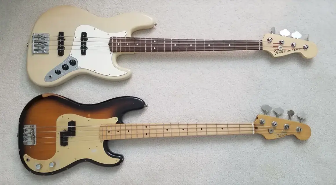 Zwei E-Bässe liegen nebeneinander: oben ein cremefarbener Jazz Bass, unten ein abgenutzter Sunburst Precision Bass.