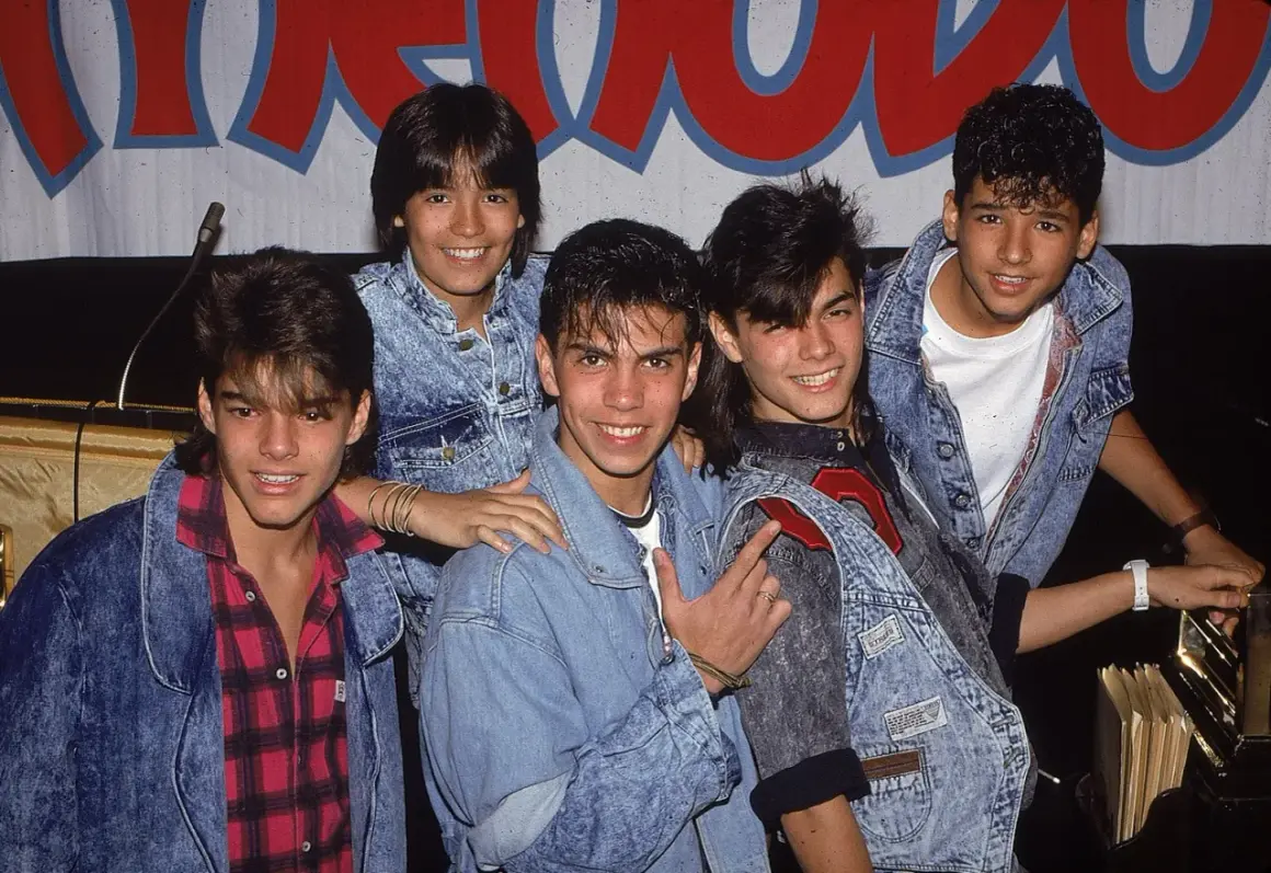 Fünf junge Männer in Jeansjacken, die wie eine Boygroup posieren.