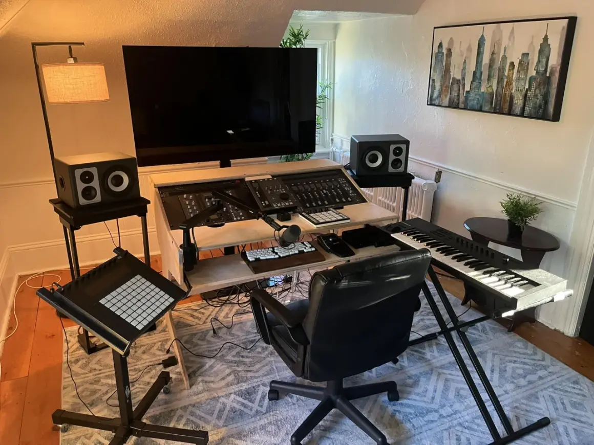 Ein Musikstudio mit einem großen Bildschirm, Mischpult, Tastatur und einem Plattenspieler für das perfekte **vinyl setup**.