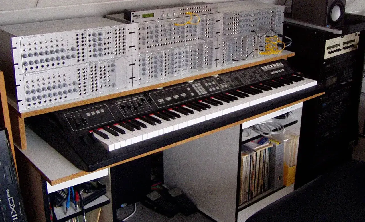 Synthesizer-Rack und Kurzweil Midiboard. Was ist MIDI? Hier wird es mit Kabeln und Knöpfen erklärt.