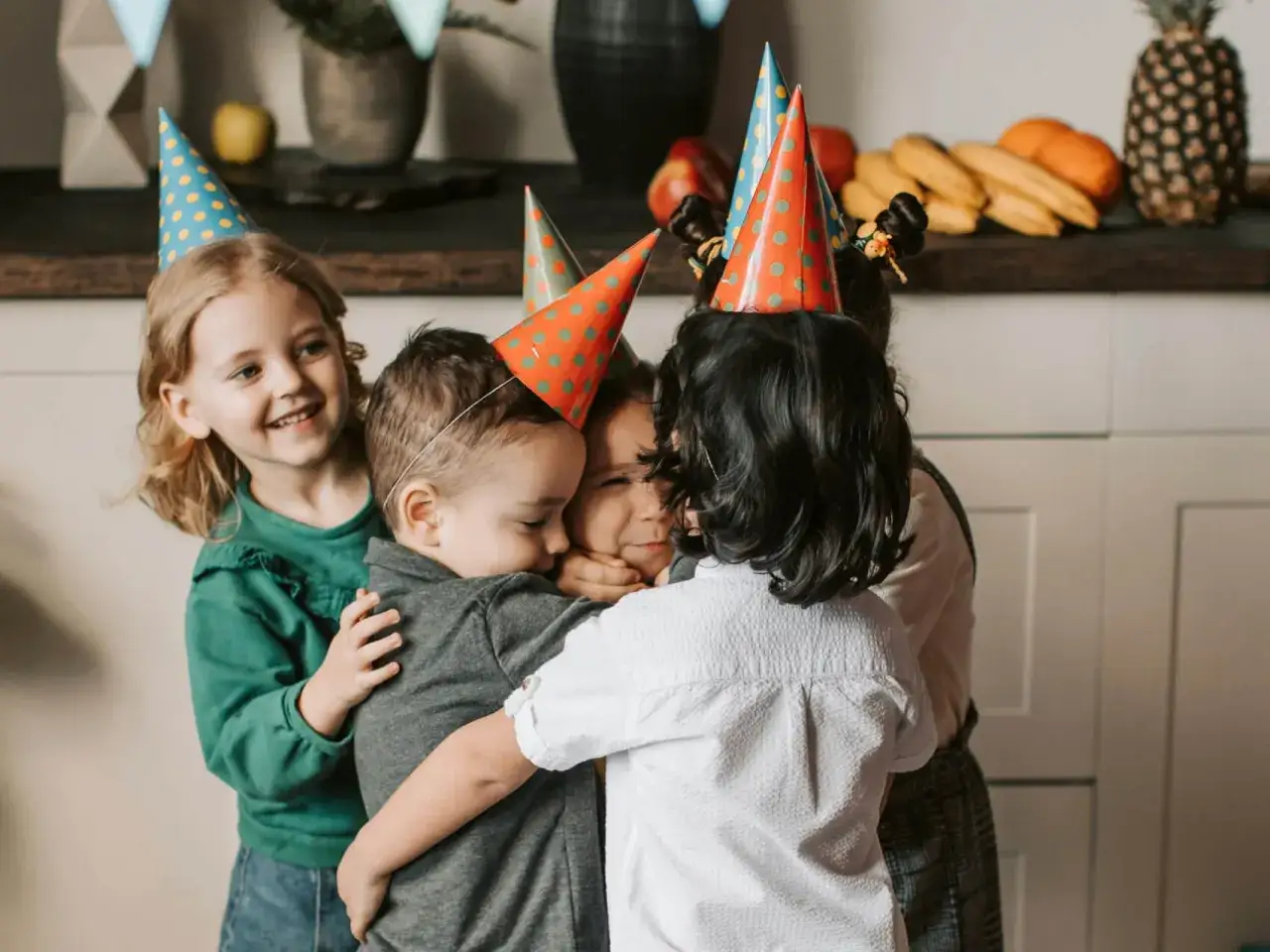 Kinder in Geburtstagshut kuscheln. Sie singen bestimmt fröhliche Geburtstagslieder, Kinderherzen schlagen höher!