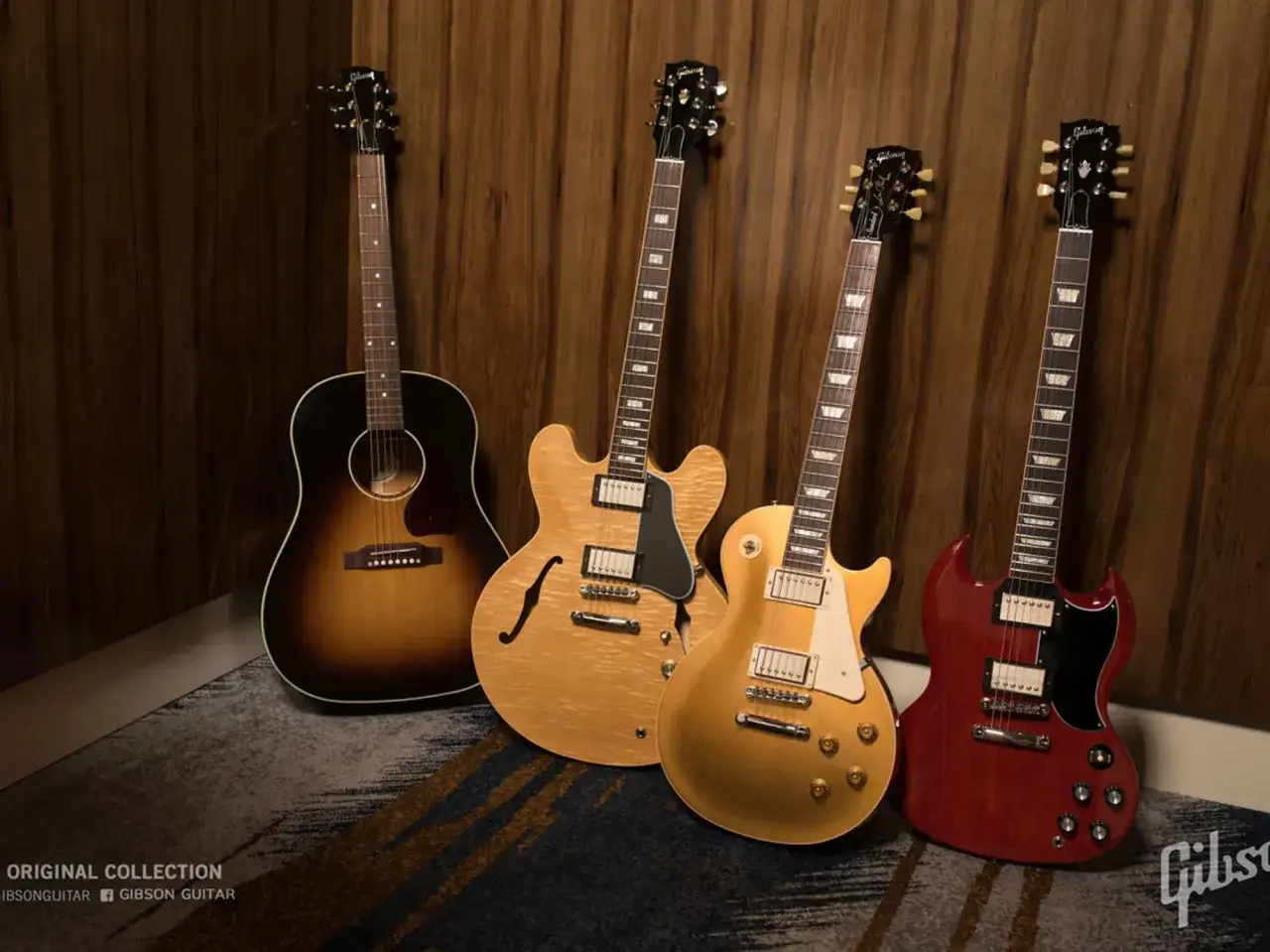 Vier ikonische Gibson Gitarren Modelle: eine Akustikgitarre, eine ES-335, eine Les Paul und eine SG, stehen nebeneinander.