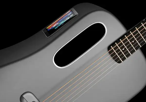 Moderne, graue Klampfe Gitarre mit integriertem Touchscreen und ovalem Schallloch.