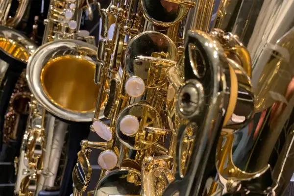 Glänzende, goldene Saxophone im Detail. Verschiedene saxophon arten sind zu sehen, mit ihren Klappen und dem Schallstück.